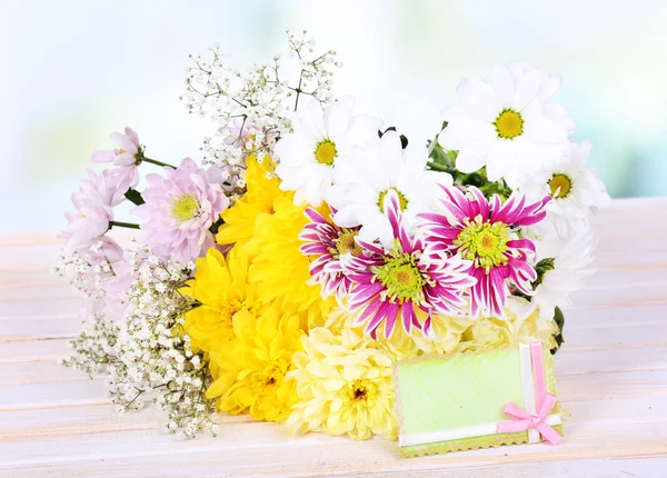 Lindas flores de crisântemo na mesa no fundo claro — Fotografia de Stock
