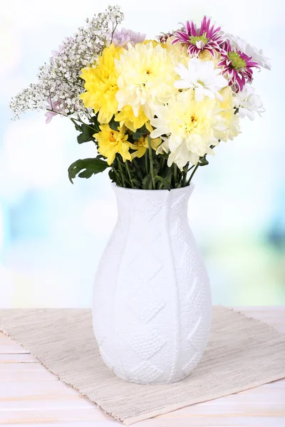 明るい背景上のテーブルの上に花瓶に美しい菊の花 — ストック写真