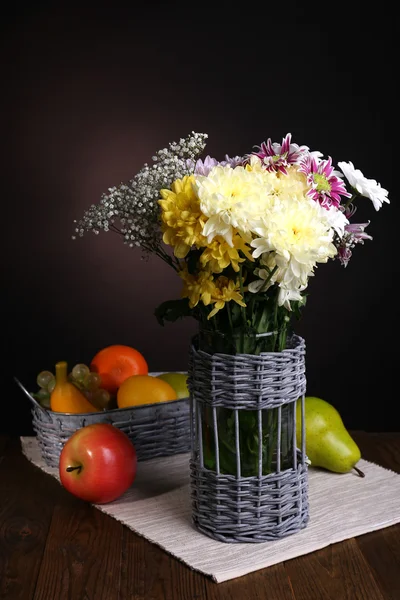 Mooie chrysant bloemen in vaas op tafel op bruine achtergrond — Stockfoto