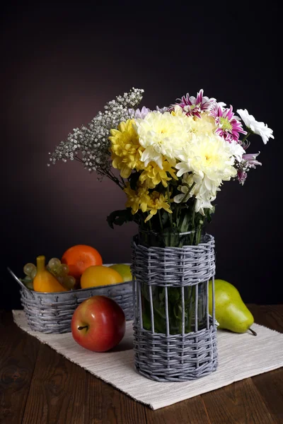 Beautiful chrysanthemum flowers in vase on table on brown background — Stock Photo, Image