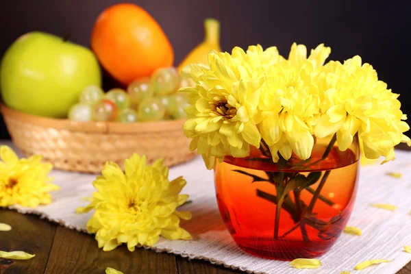 Beautiful chrysanthemum flowers in vase on table on dark  background — Stock Photo, Image