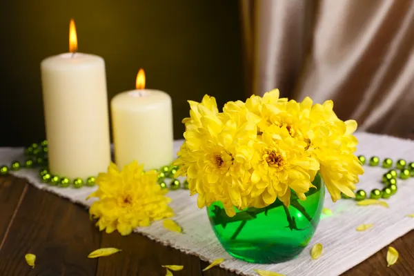 Lindas flores de crisântemo em vaso na mesa no fundo amarelo escuro — Fotografia de Stock