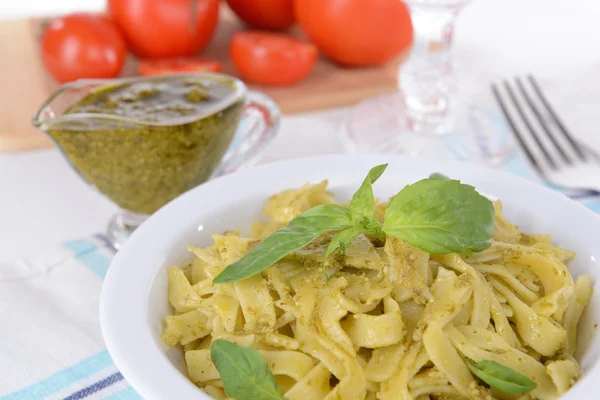 Massa deliciosa com pesto no prato na mesa close-up — Fotografia de Stock