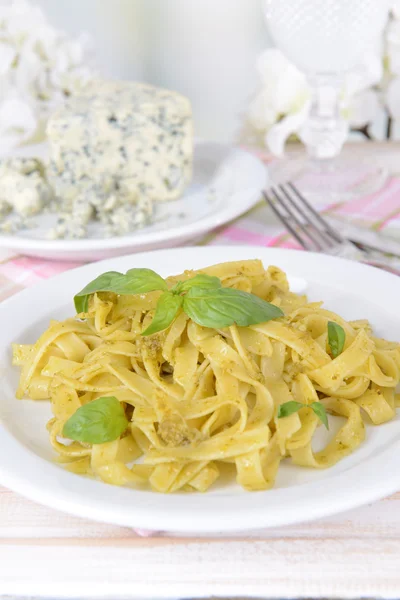Läckra pasta med pesto på tallriken på bordet på ljus bakgrund — Stockfoto