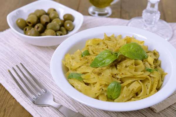 Läckra pasta med pesto på tallriken på bordet närbild — Stockfoto