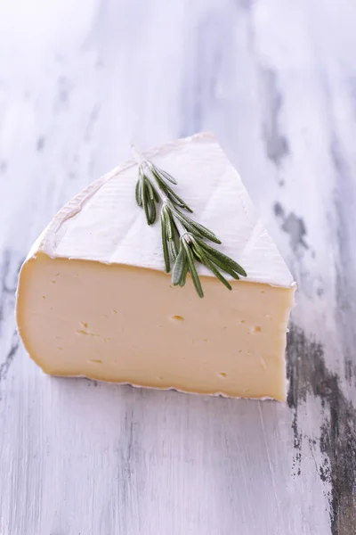 Chutný sýr camembert s rozmarýnem, na dřevěný stůl — Stock fotografie