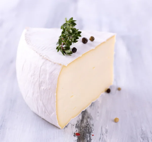 Sabroso queso Camembert con especias, sobre mesa de madera —  Fotos de Stock