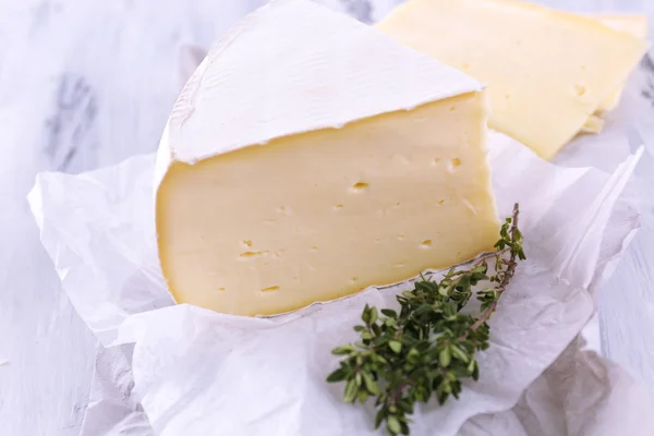 Tasty Camembert cheese with thyme, on wooden table — Stock Photo, Image