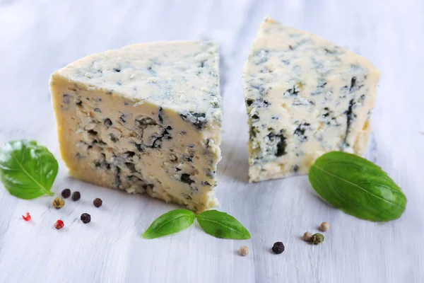 Tasty blue cheese with basil and spices on wooden table — Stock Photo, Image