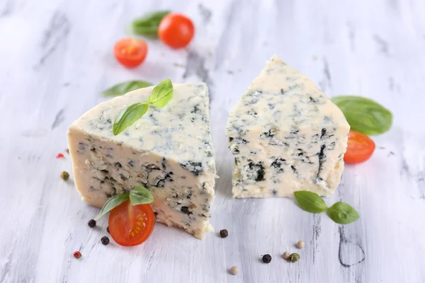 Вкусный голубой сыр с помидорами, базиликом и специями на деревянном столе — стоковое фото