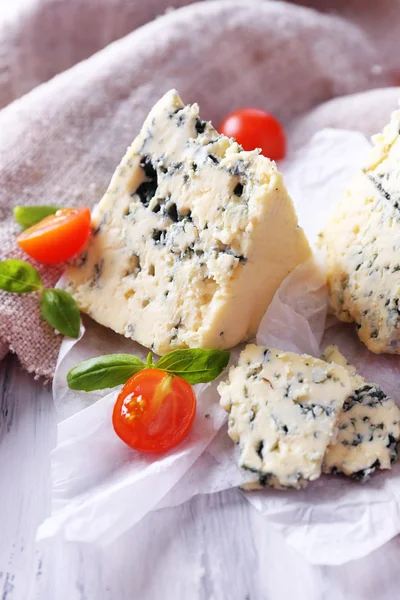 Queijo azul saboroso com tomate e manjericão sobre papel — Fotografia de Stock