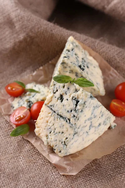 Tasty blue cheese with tomatoes and basil, on burlap background — Stock Photo, Image