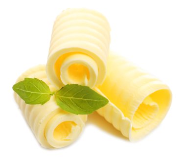 Curls of fresh butter with basil, isolated on white clipart