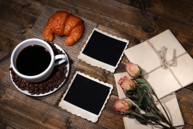 kahve fincanı, mektuplar, kuru çiçekler ve ahşap zemin üzerinde eski boş fotoğraf