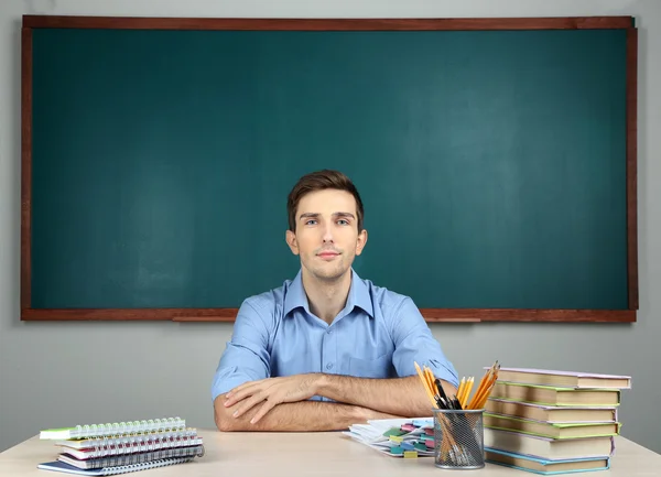 Young teacher sitting in school classroom — Stock Photo, Image