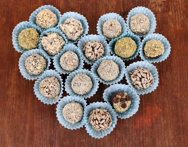 Conjunto de bombones de chocolate, sobre fondo de madera — Foto de Stock