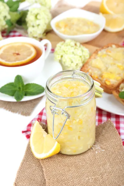 Engarrafamento de limão saboroso com xícara de chá na mesa close-up — Fotografia de Stock