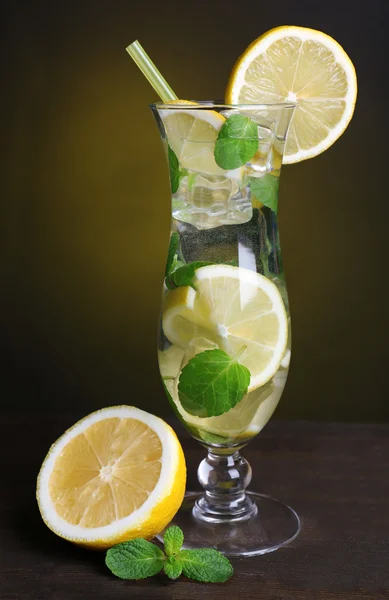 Vaso de cóctel con limón y menta sobre mesa sobre fondo amarillo oscuro —  Fotos de Stock