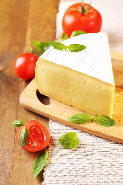 Queijo saboroso Camembert com tomate e manjericão, sobre mesa de madeira — Fotografia de Stock