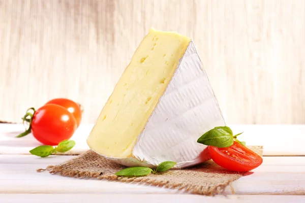 Välsmakande camembert ost med basilika och tomater, på träbord — Stockfoto