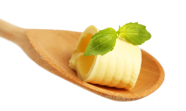 Curl of fresh butter with basil on wooden spoon, isolated on white — Stock Photo, Image