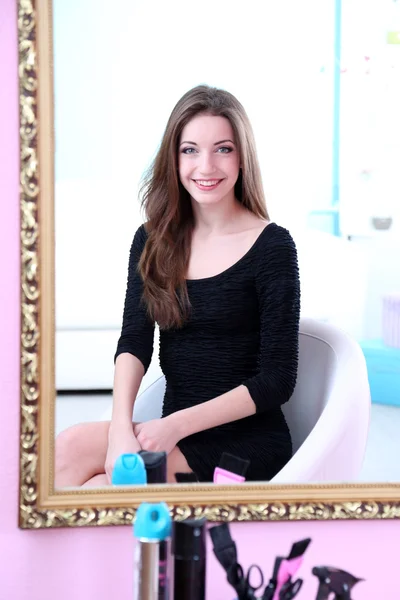 Młoda piękna kobieta siedzi przed lustro w pokoju — Zdjęcie stockowe