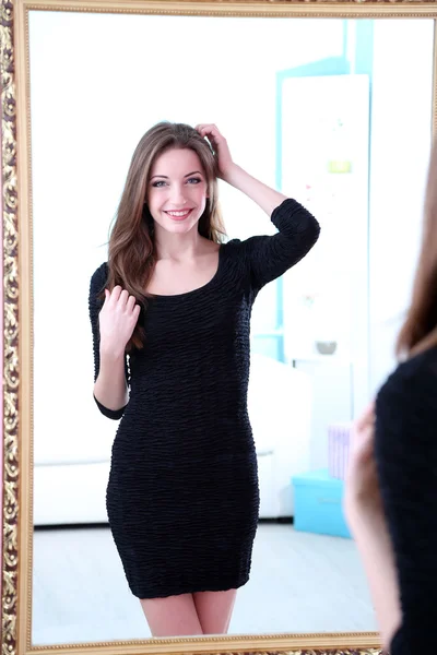 Young beautiful woman standing front of mirror in room — Stock Photo, Image