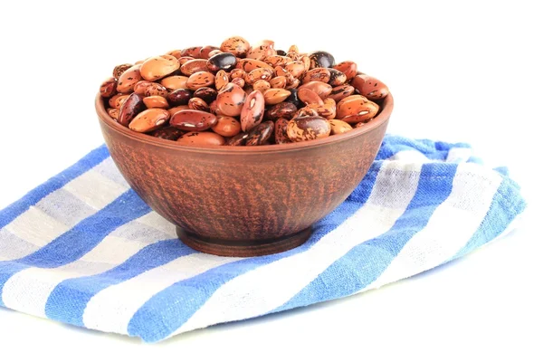 Raw beans in bowl on color napkin, isolated on white — Stock Photo, Image