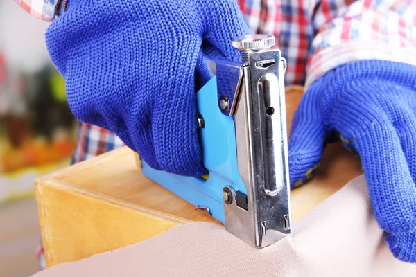 Fastening fabric and wooden box using construction stapler close up — Stock Photo, Image