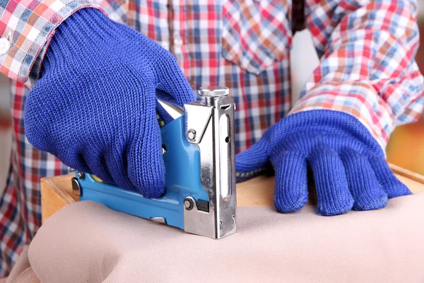 Bevestigingssystemen weefsel en houten doos met behulp van bouw nietmachine op lichte achtergrond — Stockfoto