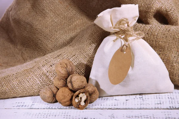 Sack full with spices, on wooden table, on sackcloth background — Stock Photo, Image