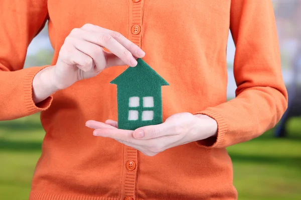 Little paper house in hand close-up, on bright background — Stock Photo, Image