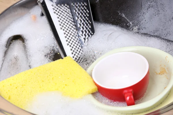 Utensils soaking in kitchen sink — Stock Photo, Image