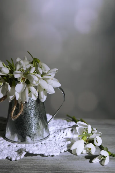Красивые подснежники в металлической вазе на сером фоне — стоковое фото