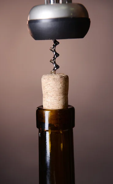 Corkscrew with bottle of wine on wooden background — Stock Photo, Image