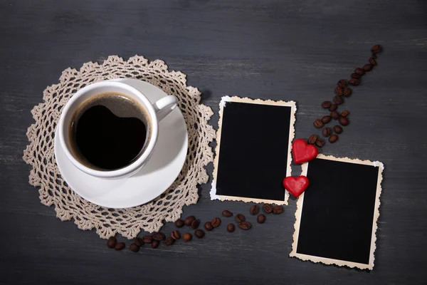 Composition avec tasse à café, cœurs décoratifs et vieilles photos vierges, sur fond en bois — Photo