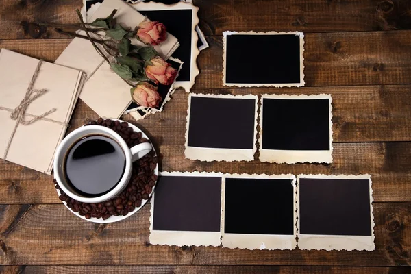 Una tazza di caffè. fiori secchi e vecchie foto in bianco, su sfondo di legno — Foto Stock