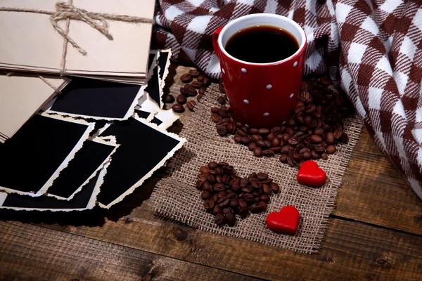 Composición con taza de café, corazones decorativos, especias a cuadros y viejas fotos en blanco, sobre fondo de madera —  Fotos de Stock