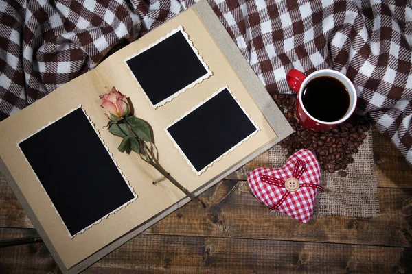Composición con taza de café, corazones decorativos, cuadros y álbum de fotos, sobre fondo de madera —  Fotos de Stock
