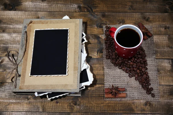 Composizione con tazza di caffè e album fotografico, su sfondo di legno — Foto Stock