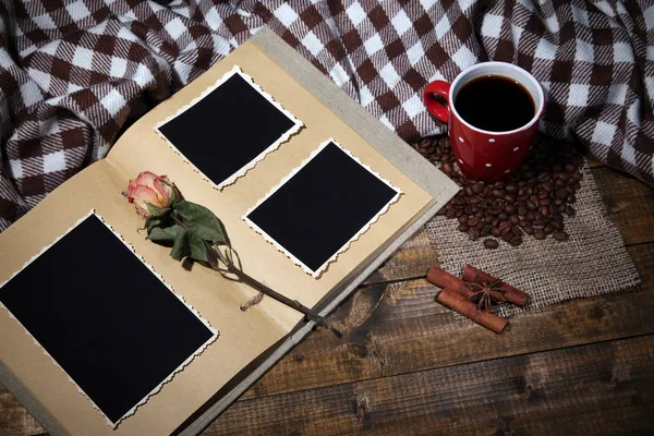 Композиция с чашкой кофе, клетчатый и фотоальбом, на деревянном фоне — стоковое фото