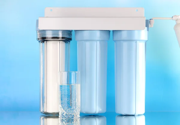 Système de filtration pour le traitement de l'eau avec verre sur fond bleu — Photo