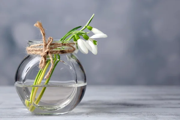 Beautiful bouquet of snowdrops in vase on light background — Stock Photo, Image