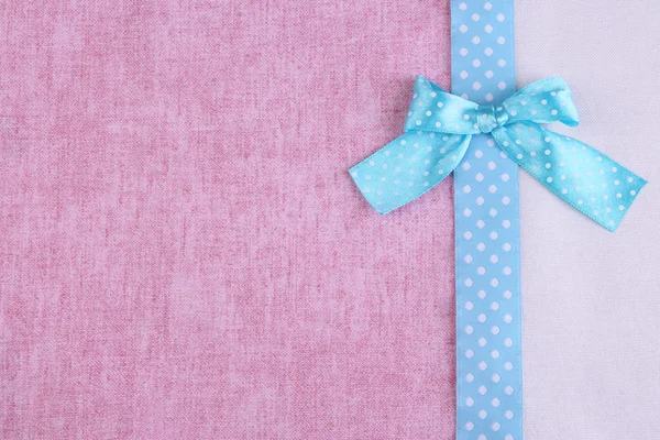 Color ribbon and bow on two color fabrics background — Stock Photo, Image