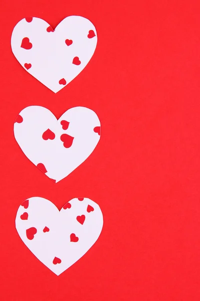 Kağıt kalpler kırmızı zemin üzerine — Stok fotoğraf