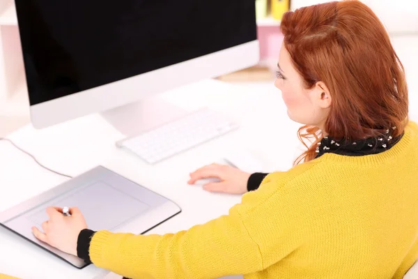 Mujer joven diseñador gráfico que trabaja con pen tablet en el lugar de trabajo — Foto de Stock