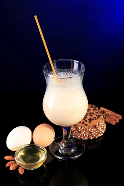 Eggnog with spices and orange on colorful background — Stock Photo, Image