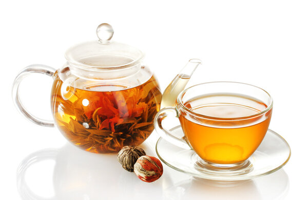 exotic green tea with flowers in glass teapot and cup isolated on white