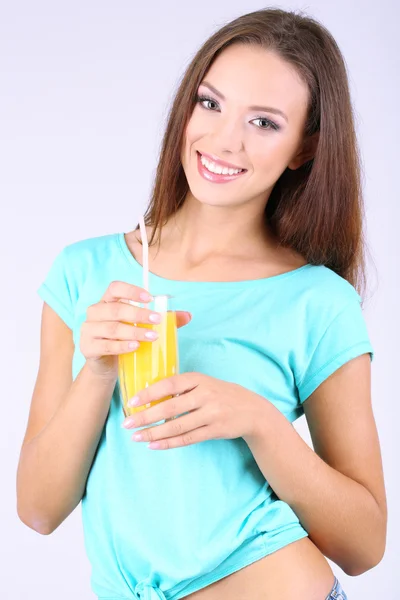 Beautiful girl with fresh juice on grey background — Stock Photo, Image