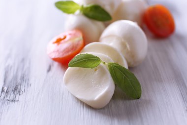 ahşap masa üstünde domates ve fesleğen ile lezzetli mozzarella peyniri